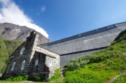 A tiny chapel in front of a giant dam